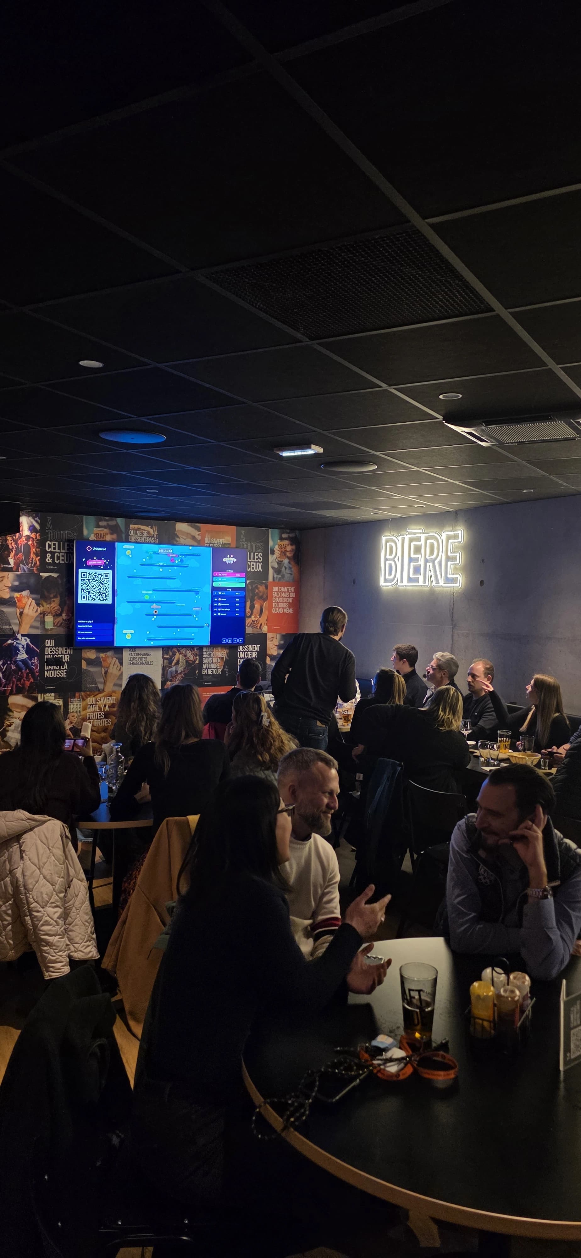 Soirée Unboared dans un bar Ninkasi : la salle est pleine, tous les clients jouent téléphone en main face à la TV